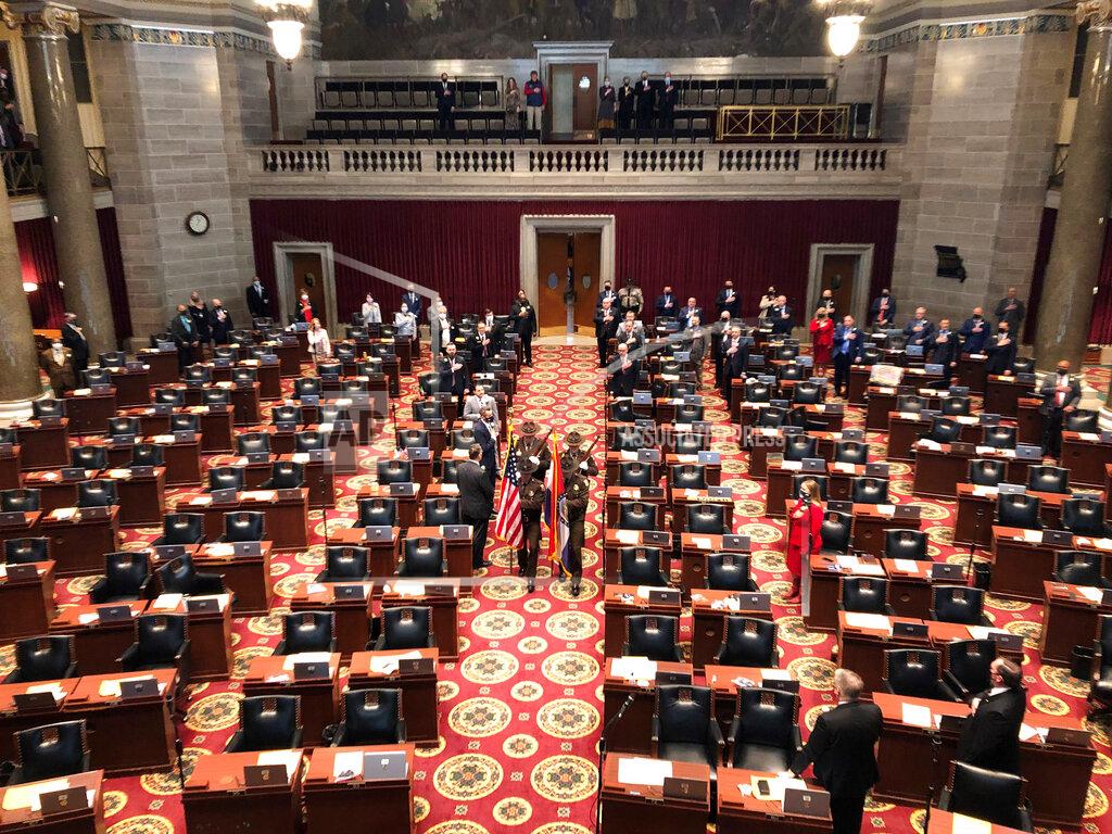 A Color Guard enters the Missouri House chamber to open the 2021 legislative session on Wednesday, Jan. 6, 2021, in Jefferson City, Missouri. Only the more senior incumbent lawmakers were present in order to try to reduce the number of guests in the galleries as a COVID-19 precaution. Newer lawmakers were later added to the floor, filling up the chamber. (AP Photo/David A. Lieb)