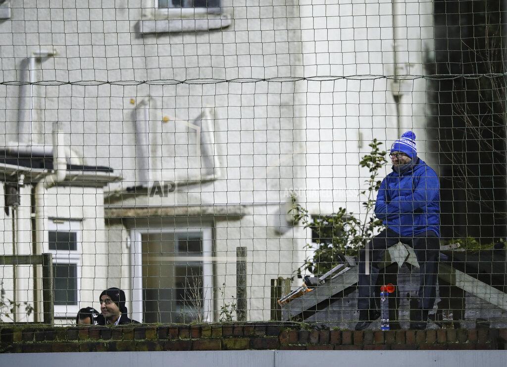Clive Brunskill A fan seated on a garden shed watches the English FA Cup third round soccer match between Marine and Tottenham Hotspur at Rossett Park stadium in Crosby, Liverpool, Sunday, Jan. 10, 2021. (Clive Brunskill/Pool via AP)