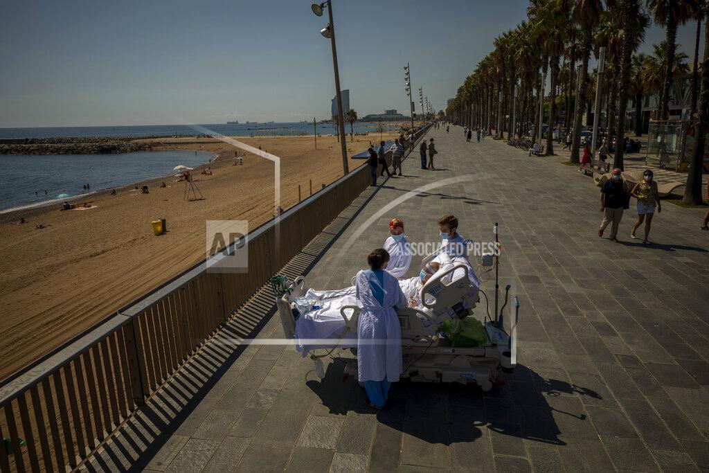 Emilio Morenatti FILE - In this Sept. 4, 2020, file photo, Francisco Espana, 60, is surrounded by members of his medical team as he looks at the Mediterranean sea from a promenade next to the "Hospital del Mar" in Barcelona, Spain. Francisco spent 52 days in the Intensive Care unit at the hospital due to coronavirus, but today he was allowed by his doctors to spend almost ten minutes at the seaside as part of his recovery therapy. (AP Photo/Emilio Morenatti, File)