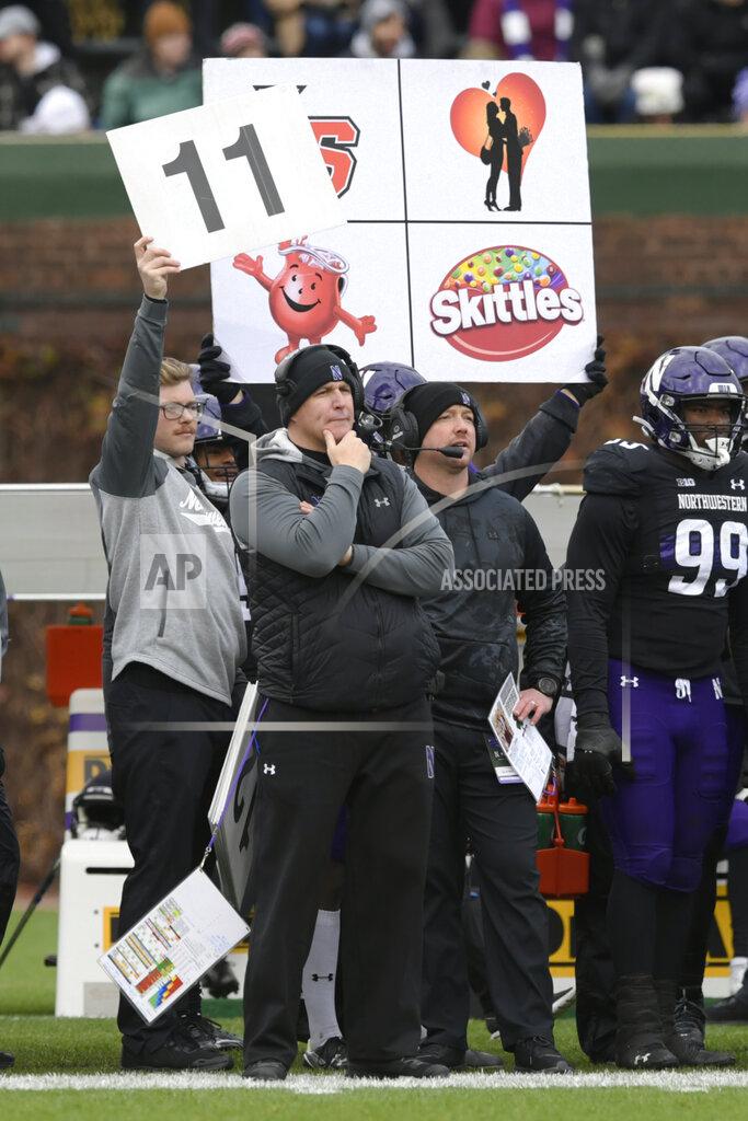 Paul Beaty Northwestern head coach Pat Fitzgerald front, looks on as play cards are held above him during the second half of an NCAA college football game against Purdue, Saturday, Nov. 20, 2021 at Wrigley Field in Chicago. Purdue won 32-14. (AP Photo/Paul Beaty)