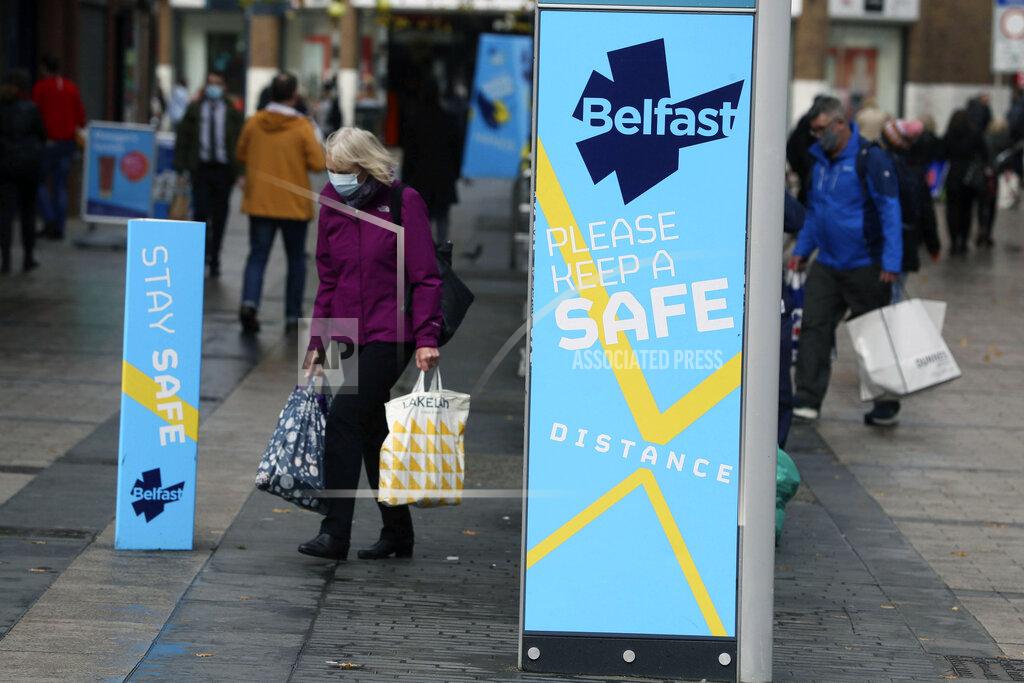 Brian Lawless FILE - In this Oct. 14, 2020, file photo, a woman wears a face mask in central Belfast as Northern Ireland introduced the tightest COVID-19 restrictions in the United Kingdom, closing schools for two weeks and pubs and restaurants for a month. After shutdowns swept nations during the virus's first surge earlier this year, some nations and U.S. states are trying more targeted measures as cases rise again around the world, especially in Europe and the Americas. (Brian Lawless/PA via AP)