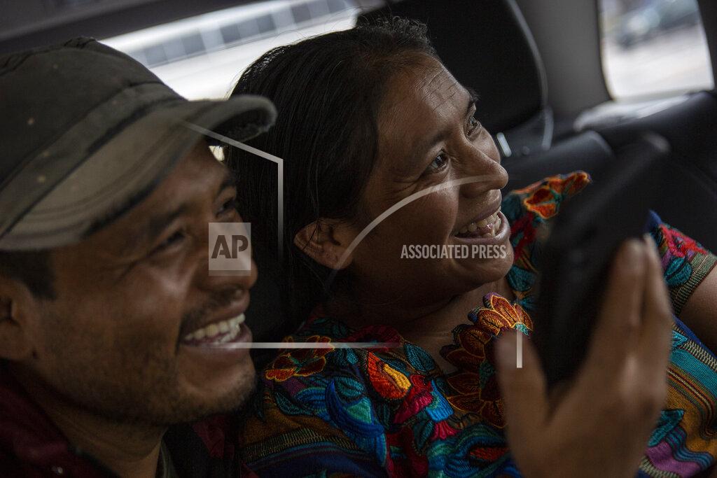 Oliver De Ros Mynor Cardona and Ufemia Tomas, parents of Yenifer Yulisa Cardona Tomás, smile as they talk with her through a call to the hospital where she is being treated in Guatemala City, Monday, July 4, 2022. Yenifer Yulisa Cardona Tomás is one of the survivors of the more than 50 migrants who were found dead inside a tractor-trailer near San Antonio, Texas. (AP Photo/Oliver de Ros)