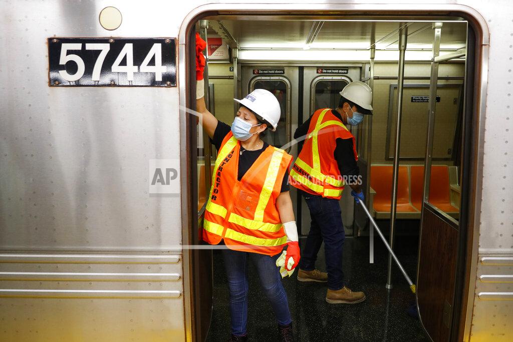 John Minchillo Contractors clean subway cars at the 96th Street station to control the spread of COVID-19, Thursday, July 2, 2020, in New York. Mass transit systems around the world have taken unprecedented — and expensive — steps to curb the spread of the coronavirus, including shutting down New York subways overnight and testing powerful ultraviolet lamps to disinfect seats, poles and floors. (AP Photo/John Minchillo)