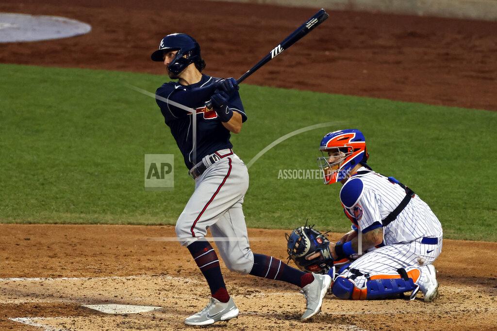 Adam Hunger Atlanta Braves' Dansby Swanson watches his two-run double in front of New York Mets catcher Tomás Nido during the third inning of a baseball game Sunday, July 26, 2020, in New York. (AP Photo/Adam Hunger)