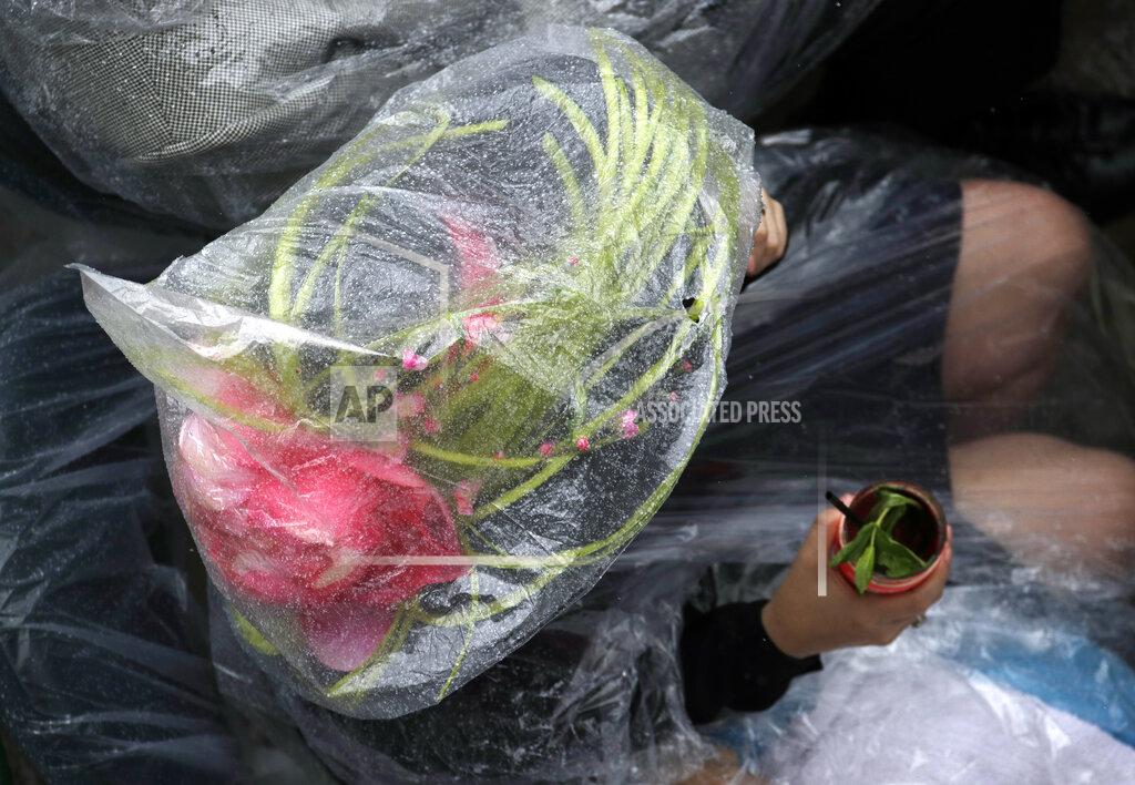 Charlie Riedel A race fan sits under the plastic cover from the rain during the 145th running of the Kentucky Derby horse race at Churchill Downs Saturday, May 4, 2019, in Louisville, Ky. (AP Photo/Charlie Riedel)