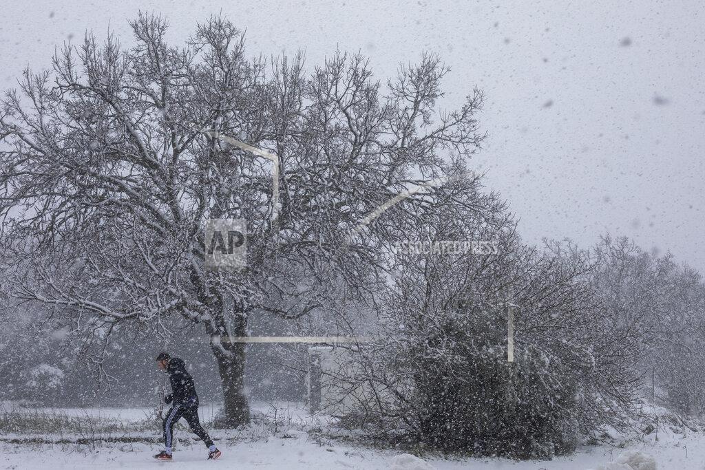Ariel Schalit A man walks in the snow near the Quneitra border crossing between Syria and the Israeli-controlled Golan Heights Wednesday, Feb. 17, 2021. (AP Photo/Ariel Schalit)