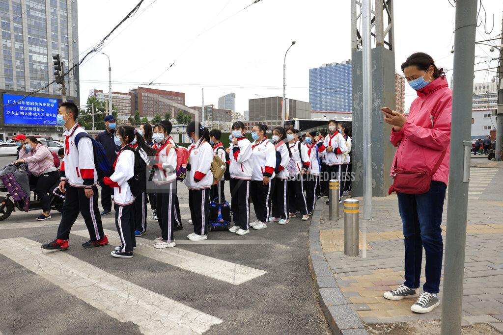 Ng Han Guan School children wearing masks line up to cross a busy traffic junction in Beijing on Thursday, April 29, 2021. China's population grew last year, the government said Thursday, following a news report a once-a-decade census might have found a decline, possibly adding to downward pressure on economic growth. (AP Photo/Ng Han Guan)