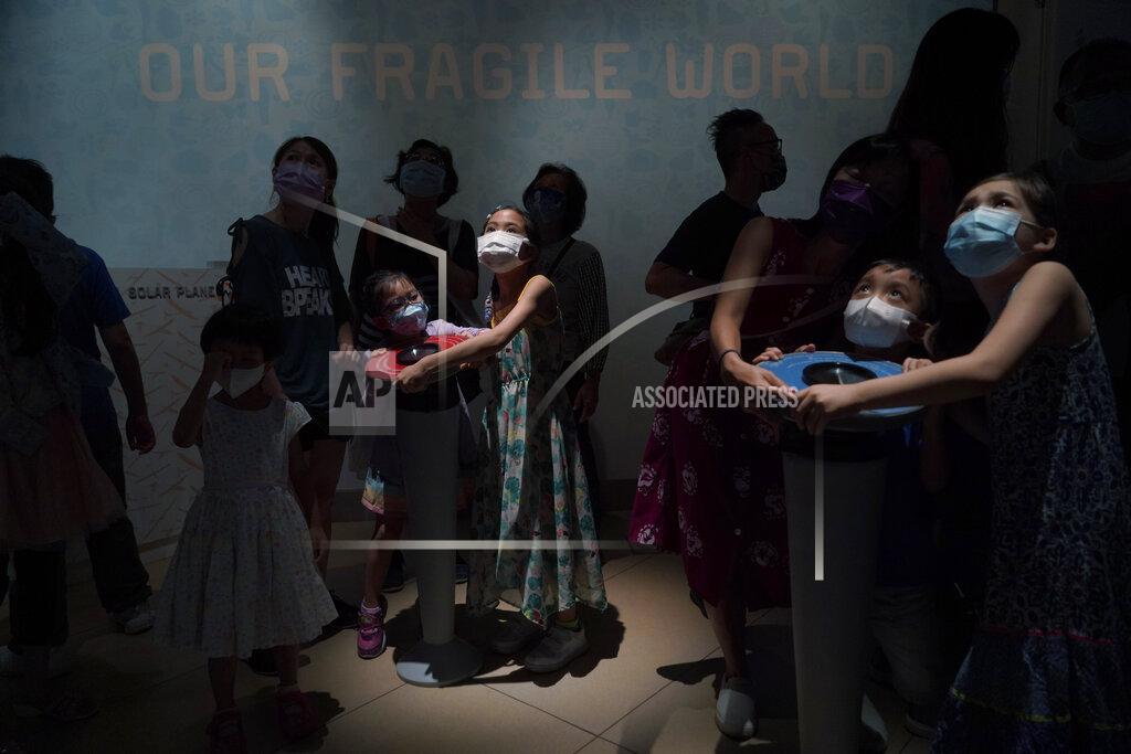 Kin Cheung Visitors wearing face masks to prevent the spread of coronavirus, control the mock solar energy planes in the Hong Kong Science Museum, Wednesday, May 19, 2021. (AP Photo/Kin Cheung)
