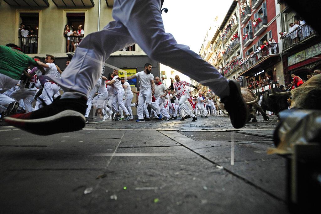 Alvaro Barrientos People run through the streets with fighting bulls and steers during the first day of the running of the bulls at the San Fermin Festival in Pamplona, northern Spain, Thursday, July 7, 2022. Revelers from around the world flock to Pamplona every year for nine days of uninterrupted partying in Pamplona's famed running of the bulls festival which was suspended for the past two years because of the coronavirus pandemic. (AP Photo/Alvaro Barrientos)