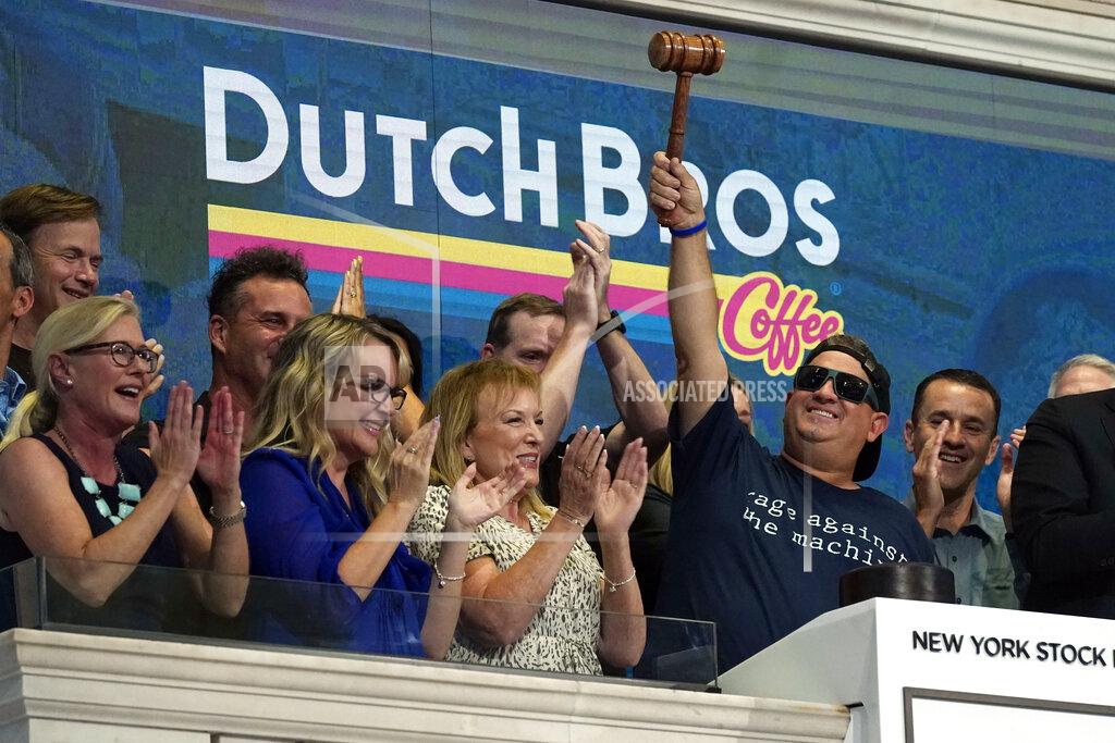 Richard Drew Dutch Bros Coffee Co-founder and Executive Chairman Travis Boersma, right, raises the gavel after ringing the New York Stock Exchange closing bell, Wednesday, Sept. 15, 2021. (AP Photo/Richard Drew)