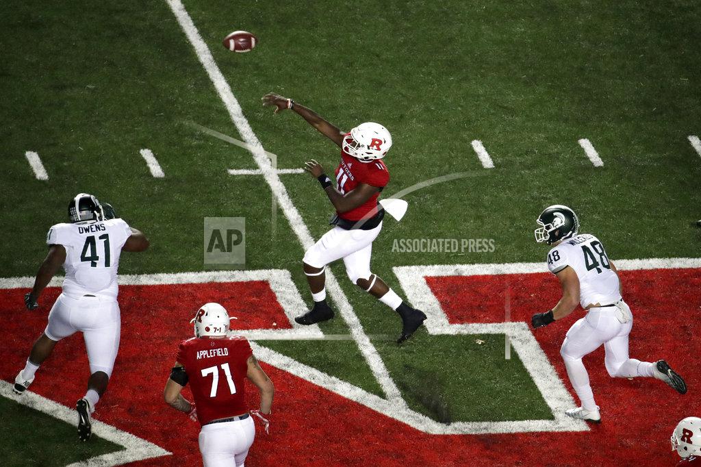 Julio Cortez Rutgers quarterback Johnathan Lewis, center, throws a touchdown pass to running back Raheem Blackshear (not shown) as Michigan State defensive lineman Gerald Owens (41) and defensive end Kenny Willekes (48) try to get to him during the first half of an NCAA college football game, Saturday, Nov. 25, 2017, in Piscataway, N.J. (AP Photo/Julio Cortez)