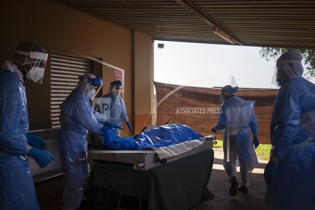 Volunteers from the Saaberie Chishty Society prepare the body of a COVID-19 victim, in Lenasia, South Africa, Wednesday, Dec. 30, 2020. For more than 30 years, the Saaberie Chishty ambulance service has responded to medical emergencies in a tight-knit Muslim community in Johannesburg. Now, as COVID-19 sweeps through, the service has greatly expanded to offer oxygen and home care. Confronted by an increased number of deaths, it also provides safe body preparation and burial to assure that people are still buried according to Muslim tradition. (AP Photo/Bram Janssen)