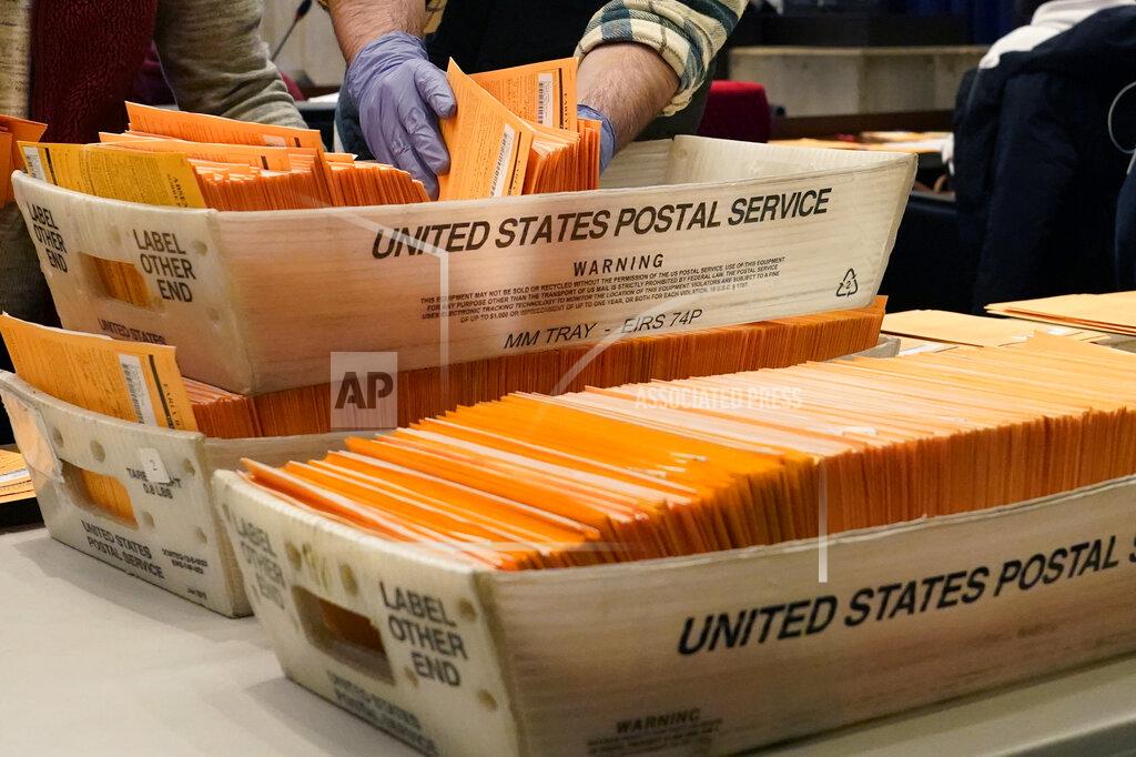 Elise Amendola FILE - In this Nov. 2, 2020, file photo, Election officials sort absentee and early voting ballots for counting inside Boston City Hall in Boston. Democrats plan to move quickly on one of the first bills of the new Congress, which would set federal election standards. The For the People Act would require states to offer early voting, same-day registration and the option of absentee voting for all registered voters. (AP Photo/Elise Amendola, File)