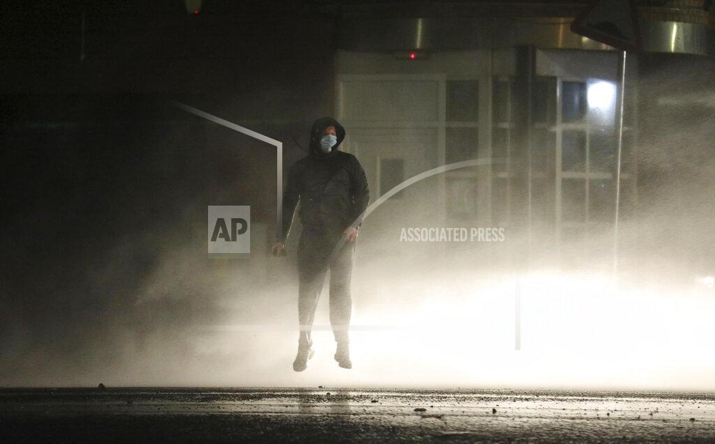 Peter Morrison FILE - In this Thursday, April 8, 2021 file photo, a Nationalist youth is lifted off the ground by a police water cannon near the Peace Wall in West Belfast, Northern Ireland. The chaotic scenes during a week of violence on the streets of Northern Ireland have stirred memories of decades of Catholic-Protestant conflict, known as “The Troubles.” A 1998 peace deal ended large-scale violence but did not resolve Northern Ireland’s deep-rooted tensions. (AP Photo/Peter Morrison, File)