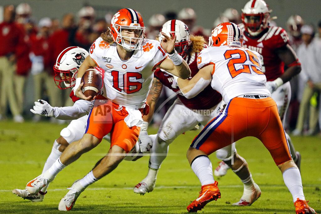 Karl B Deblaker Clemson's Trevor Lawrence (16) runs the ball around the block of teammate J.C. Chalk (25) during the first half of an NCAA college football game against North Carolina State, in Raleigh, N.C., Saturday, Nov. 9, 2019. (AP Photo/Karl B DeBlaker)