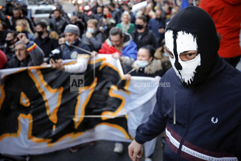 Vadim Ghirda People protesting against the COVID-19 pandemic restrictions march downtown in Bucharest, Romania, Monday, March 29, 2021. Thousands of anti-restriction protesters took to the streets in several cities across Romania on Monday evening, a day after new restriction measures came into force. (AP Photo/Vadim Ghirda)