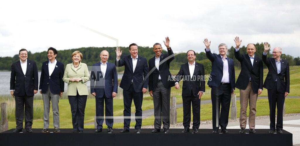 Matt Dunham FILE - In this Tuesday, June 18, 2013 file photo, leaders from left, European Commission President Jose Manuel Barroso, Japan's Prime Minister Shinzo Abe, German Chancellor Angela Merkel, Russian President Vladimir Putin, British Prime Minister David Cameron, US President Barack Obama, French President Francois Hollande, Canadian Prime Minister Stephen Harper, Italian Prime Minister Enrico Letta and European Council President Herman Van Rompuy pose during a group photo opportunity at the G-8 summit at the Lough Erne golf resort in Enniskillen, Northern Ireland. Merkel has also been lauded as an impressive role model for girls both at home and around the globe for standing up to male leaders. (AP Photo/Matt Dunham, File)