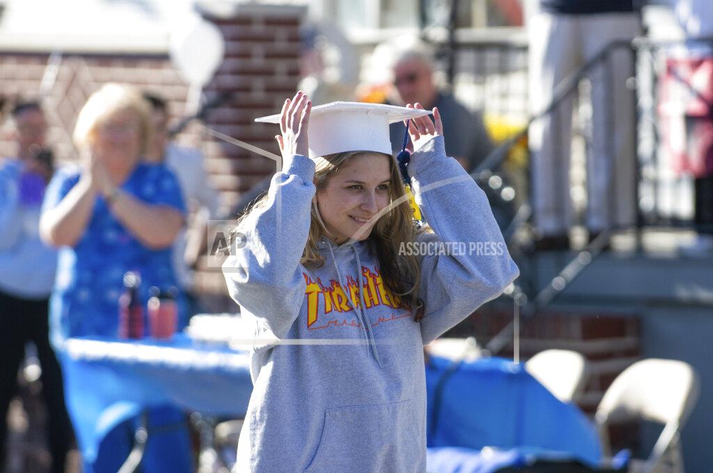 David Mckeown FILE—In this file photo from May 13, 2020, Minersville Area High School graduating senior Taylor Marks walks to receive her "quarantine diploma" on East Carbon Street, in Minersville, Pa. during a neighborhood graduation ceremony. The graduates were all presented flowers and a "quarantine diploma," made with toilet paper. Pennsylvania Gov. Tom Wolf will ask lawmakers Wednesday, Feb. 3, 2021, to raise income taxes on higher earners and give public schools a massive boost in aid, even as he faces a gaping deficit and uncertainty over how much more pandemic relief the federal government will send. (David McKeown/Republican-Herald via AP, File)