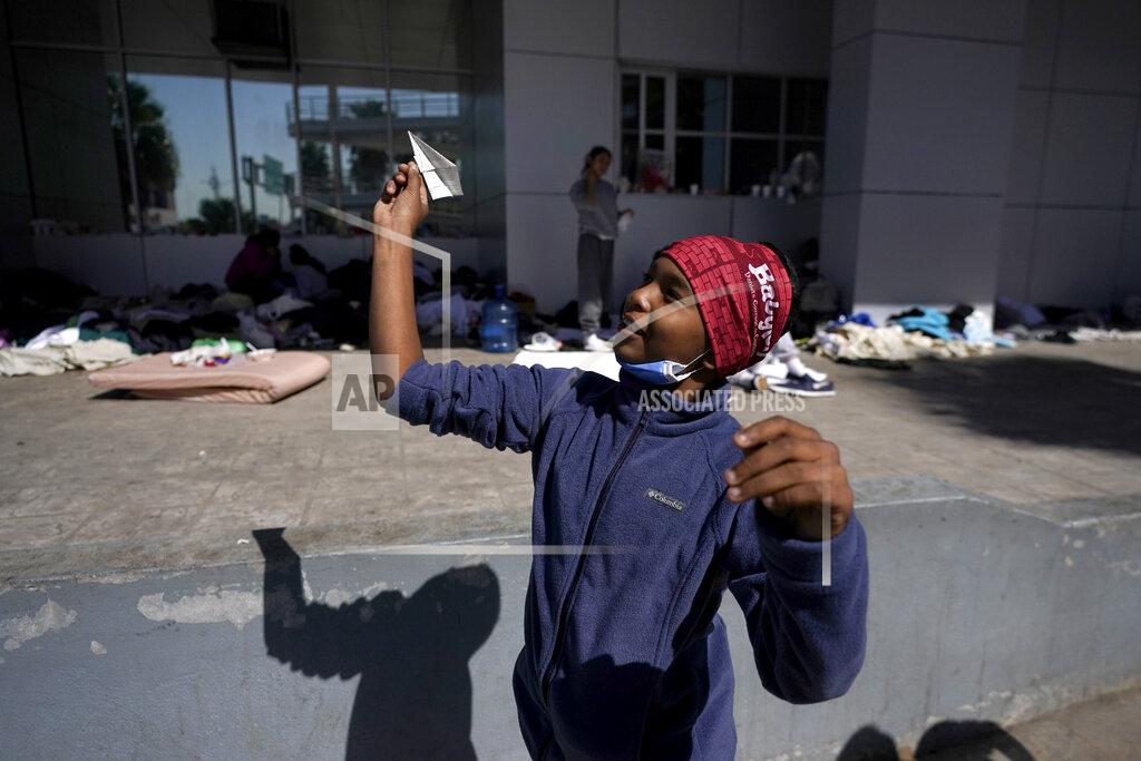 Julio Cortez A migrant boy launches a paper airplane while playing with other migrant kids at a plaza near the McAllen-Hidalgo International Bridge point of entry into the United States after being caught trying to sneak into the U.S. and deported, Thursday, March 18, 2021, in Reynosa, Mexico. A surge of migrants on the Southwest border has the Biden administration on the defensive. The head of Homeland Security acknowledged the severity of the problem Tuesday but insisted it's under control and said he won't revive a Trump-era practice of immediately expelling teens and children. (AP Photo/Julio Cortez)