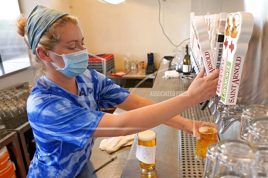 David J. Phillip Bartender Katie McGranahan pours a beer at the Saint Arnold Brewing Company, Friday, June 26, 2020, in Houston. Texas Gov. Greg Abbott announced Friday that he is shutting bars back down and scaling back restaurant capacity to 50%, in response to the increasing number of COVID-19 cases in Texas. (AP Photo/David J. Phillip)