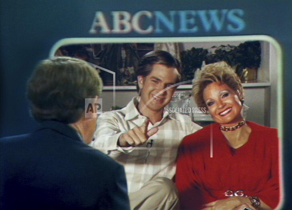 Uncredited This image released by Searhlight Pictures shows Andrew Garfield as Jim Bakker, center, and Jessica Chastain as Tammy Faye Bakker in a scene from "The Eyes of Tammy Faye." (Searchlight Pictures via AP)