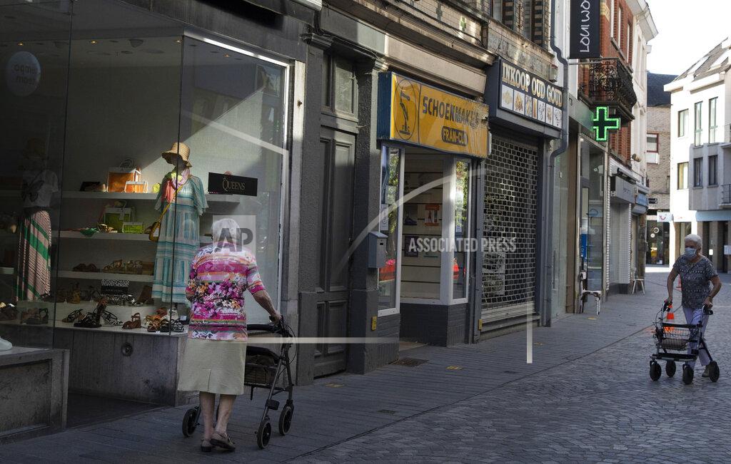 Virginia Mayo Two older women wear facemasks as they push their walkers on a shopping street, during a partial lifting of coronavirus, COVID-19, regulations in Halle, Belgium, Wednesday, June 24, 2020. (AP Photo/Virginia Mayo)