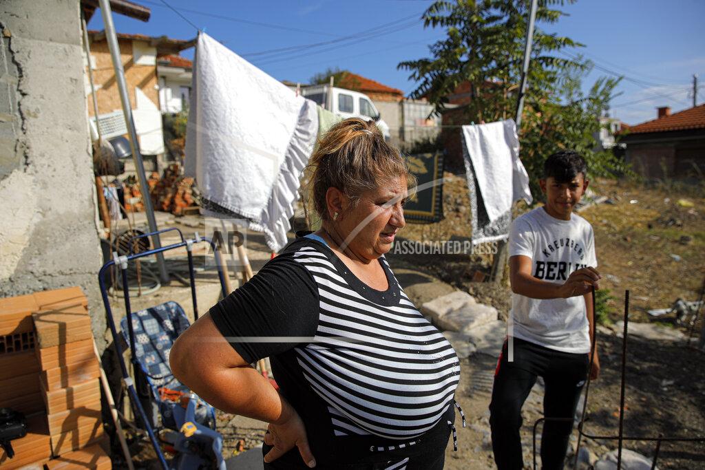 Vadim Ghirda Azime Ali Topchu, 48, a Bulgarian Roma woman, stands in her back yard in a village on the outskirts of Burgas, Bulgaria, Monday, Sept. 28, 2020. Human rights activists and experts say local officials in several countries with significant Roma populations have used the pandemic to unlawfully target the minority group, which is Europe's largest and has faced centuries of severe discrimination. Topchu said that the police-enforced lockdown of her village in Burgas, on Bulgaria's Black Sea Coast, made her family "really sad." (AP Photo/Vadim Ghirda)