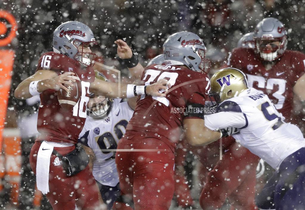 Ted S. Warren Washington State quarterback Gardner Minshew, left, struggles under pressure from Washington during the second half of an NCAA college football game, Friday, Nov. 23, 2018, in Pullman, Wash. (AP Photo/Ted S. Warren)