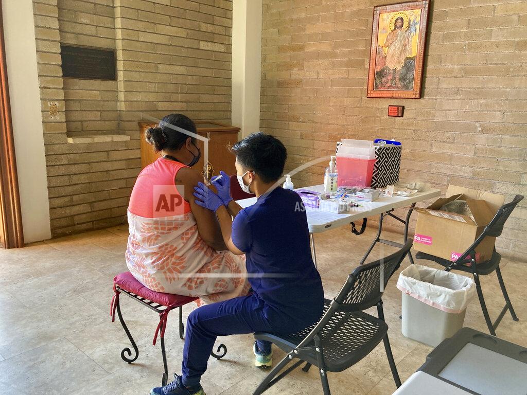 Jennifer Sinco Kelleher FILE - In this July 14, 2021 file photo, Lara Geyrozaga, a nurse with Project Vision Hawaii, administers a COVID-19 vaccine dose to Eileen Pelep at a vaccination clinic in Honolulu. Most Americans who haven’t been vaccinated against COVID-19 say they are unlikely to get the shots and doubt they would work against the aggressive delta variant despite evidence they do, according to a new poll that underscores the challenges facing public health officials amid soaring infections in some states. (AP Photo/Jennifer Since Kelleher)