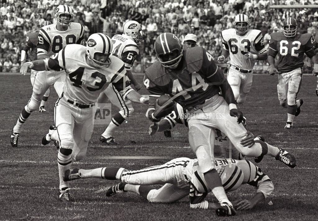 FILE - In this Sept.1969 file photo, Denver Broncos' Floyd Little avoids the tackle of New York Jets' Steve O'Neal (20) during a football game in Denver. Little, the Hall of Fame running back who starred at Syracuse and for the Denver Broncos, has died. The Pro Football Hall of Fame said he died Friday, Jan. 1, 2021. (AP Photo/File)