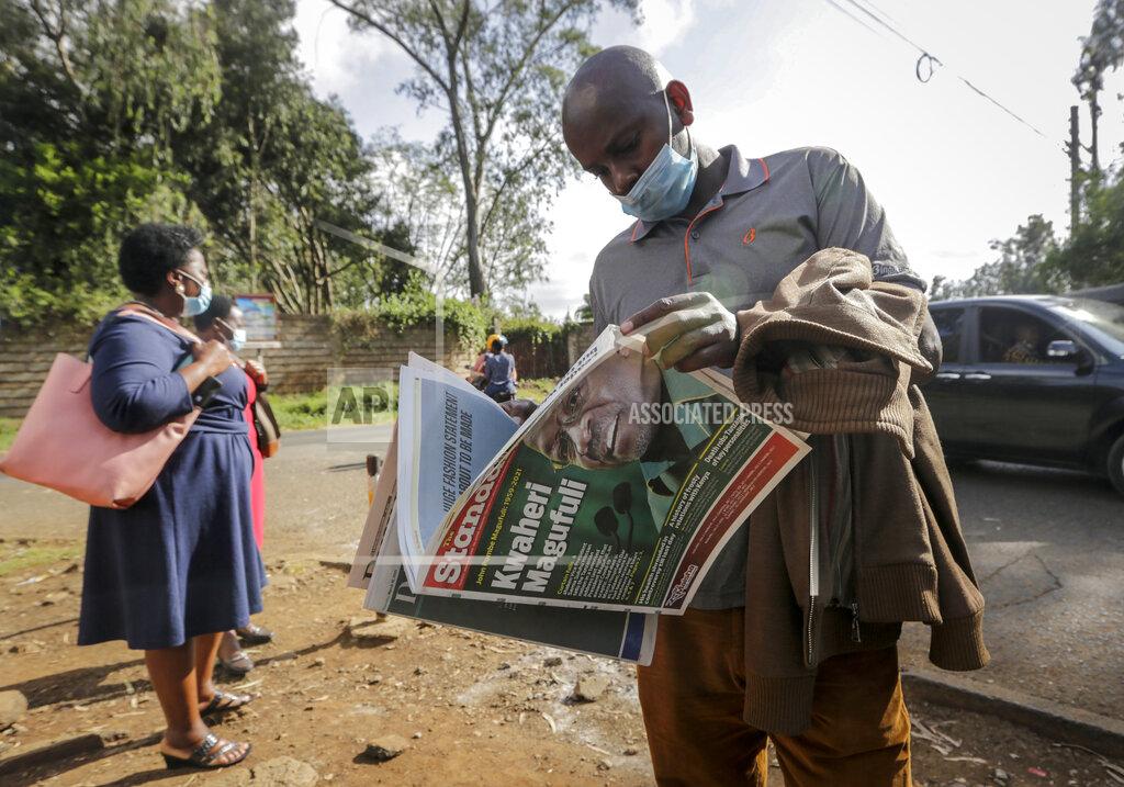 Khalil Senosi A man reads a copy of the Daily Nation morning newspaper reporting the death of neighboring Tanzania's President John Magufuli on a street in Nairobi, Kenya Thursday, March 18, 2021. Magufuli, a prominent COVID-19 skeptic whose populist rule often cast his country in a harsh international spotlight, died Wednesday aged 61 of heart failure, it was announced by Vice President Samia Suluhu. Headline in Swahili reads "Goodbye Magufuli." (AP Photo/Khalil Senosi)