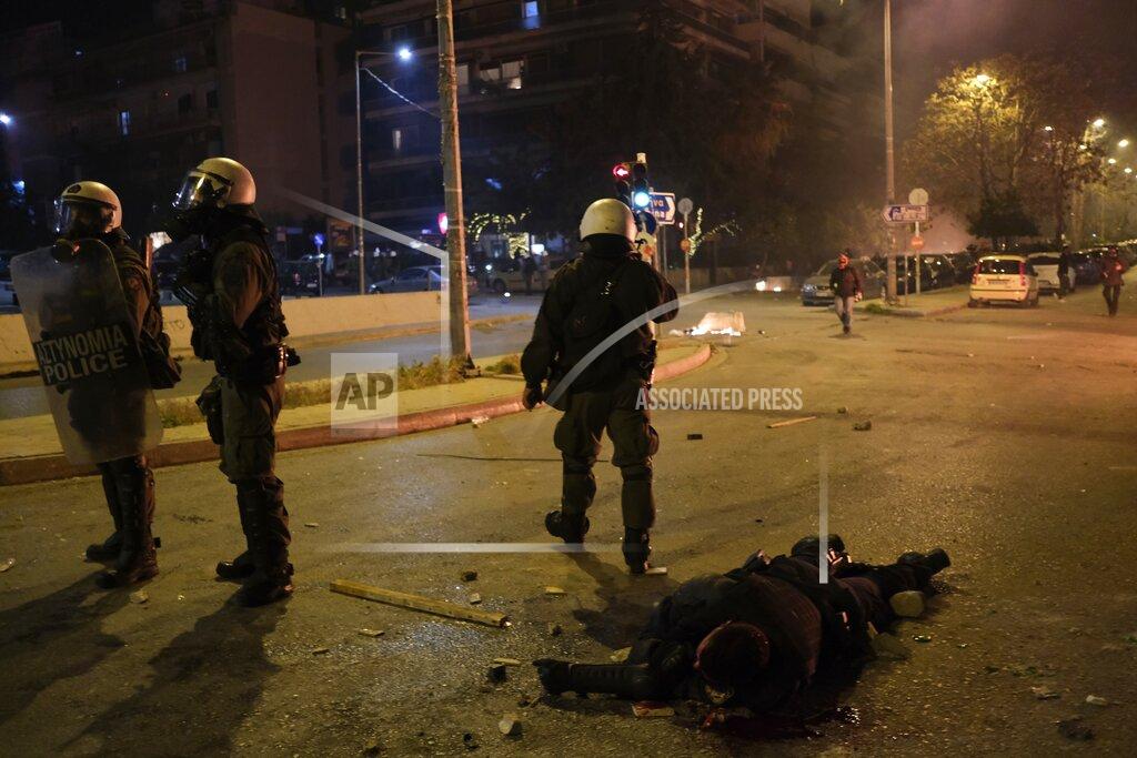 Aggelos Barai A policeman lays injured on the road after an attack by protesters during clashes in Athens, Tuesday, March 9, 2021. Severe clashes broke out Tuesday in Athens after youths protesting an incident of police violence attacked a police station with petrol bombs, and severely injured one officer. (AP Photo/Aggelos Barai)