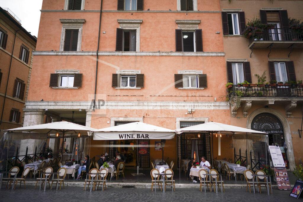 Andrew Medichini People sit at a restaurant in Piazza Navona, in Rome, Monday, Oct. 26, 2020. For at least the next month, people outdoors except for small children must now wear masks in all of Italy, gyms, cinemas, swimming pools, and movie theaters will be closed, ski slopes are off-limits to all but competitive skiers and cafes and restaurants must shut down in early evenings, under a decree signed on Sunday by Italian Premier Giuseppe Conte, who ruled against another severe lockdown despite a current surge in COVID-19 infections. (AP Photo/Andrew Medichini)