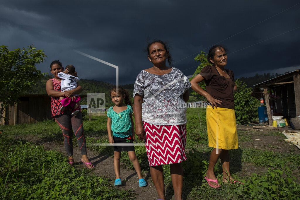 Rodrigo Abd Residents gather for a community meeting under threatening skies in Hacienda Uno, Honduras, Friday, June 25, 2021, near El Espiritu, an area historically controlled by the Valle family drug traffickers. (AP Photo/Rodrigo Abd)