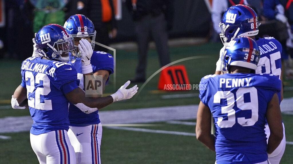 Bryan Woolston New York Giants running back Wayne Gallman (22) is congratulated by teammates after scoring a touchdown during the first half of an NFL football game against the Cincinnati Bengals, Sunday, Nov. 29, 2020, in Cincinnati. (AP Photo/Bryan Woolston)
