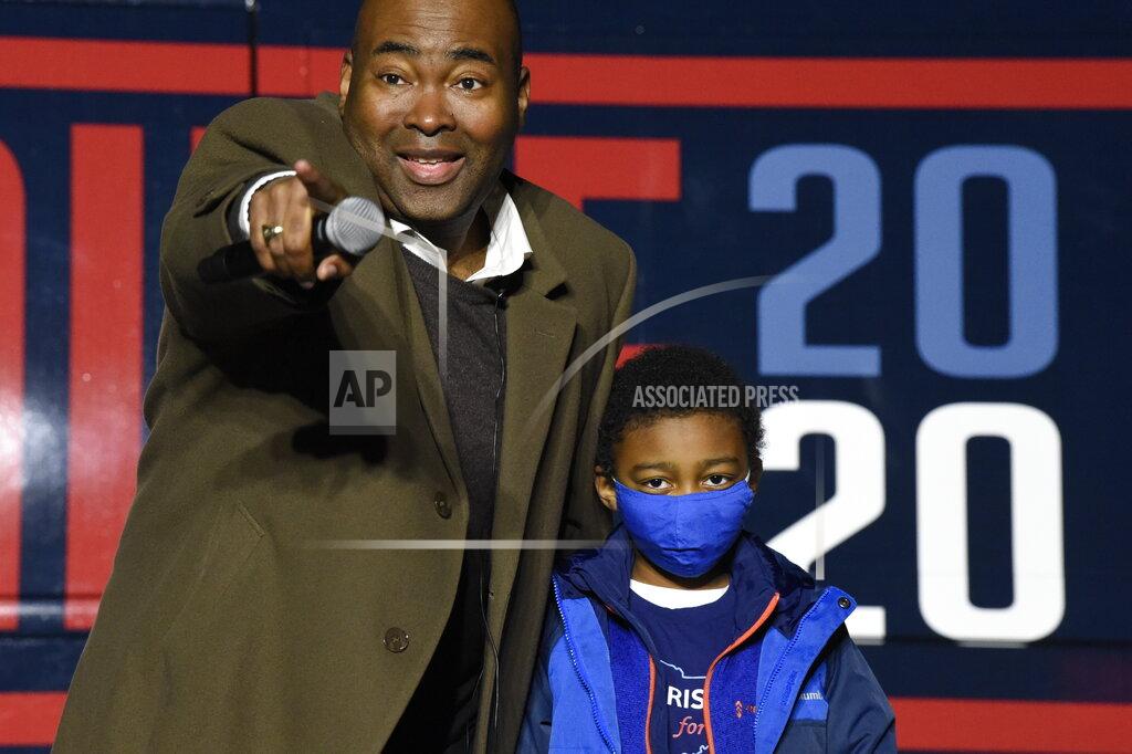 Meg Kinnard Democratic U.S. Senate candidate Jaime Harrison, left, stands with his son William, right, at a campaign rally Monday, Nov. 2, 2020, in Orangeburg, S.C. (AP Photo/Meg Kinnard)