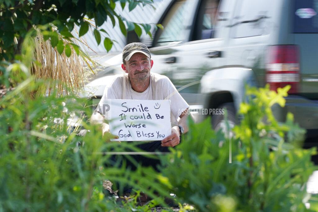 Mark Humphrey Sean Fuller, who is homeless, panhandles at the entrance to a store on May 10, 2022, in Cookeville, Tenn. Tennessee is about to become the first U.S. state to make it a felony to camp on local public property such as parks. (AP Photo/Mark Humphrey)