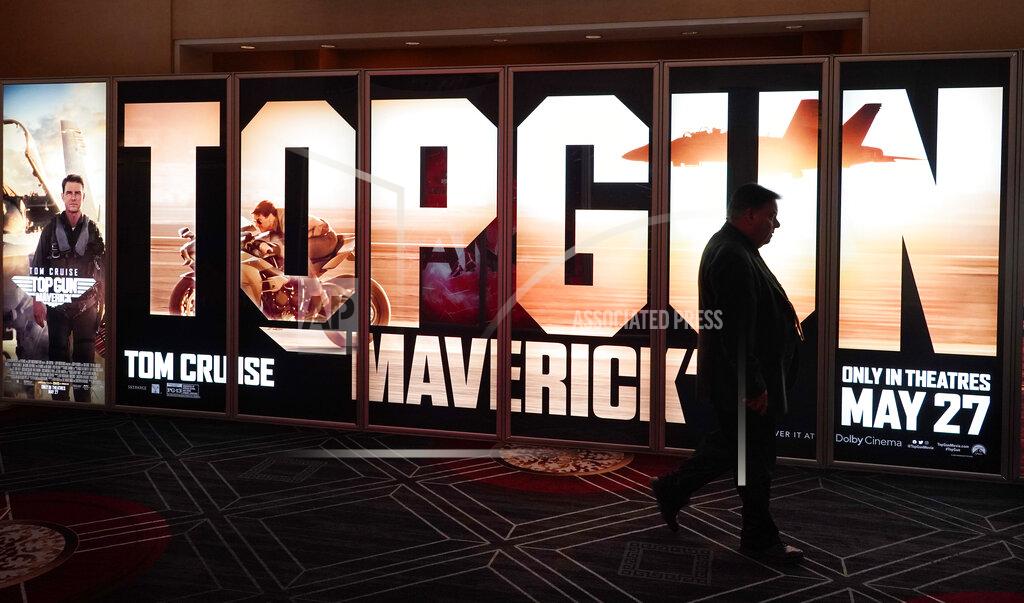 Chris Pizzello An attendee walks past an advertisement for the upcoming film "Top Gun: Maverick" on the opening day of CinemaCon 2022, the official convention of the National Association of Theatre Owners (NATO) at Caesars Palace, Monday, April 25, 2022, in Las Vegas. (AP Photo/Chris Pizzello)