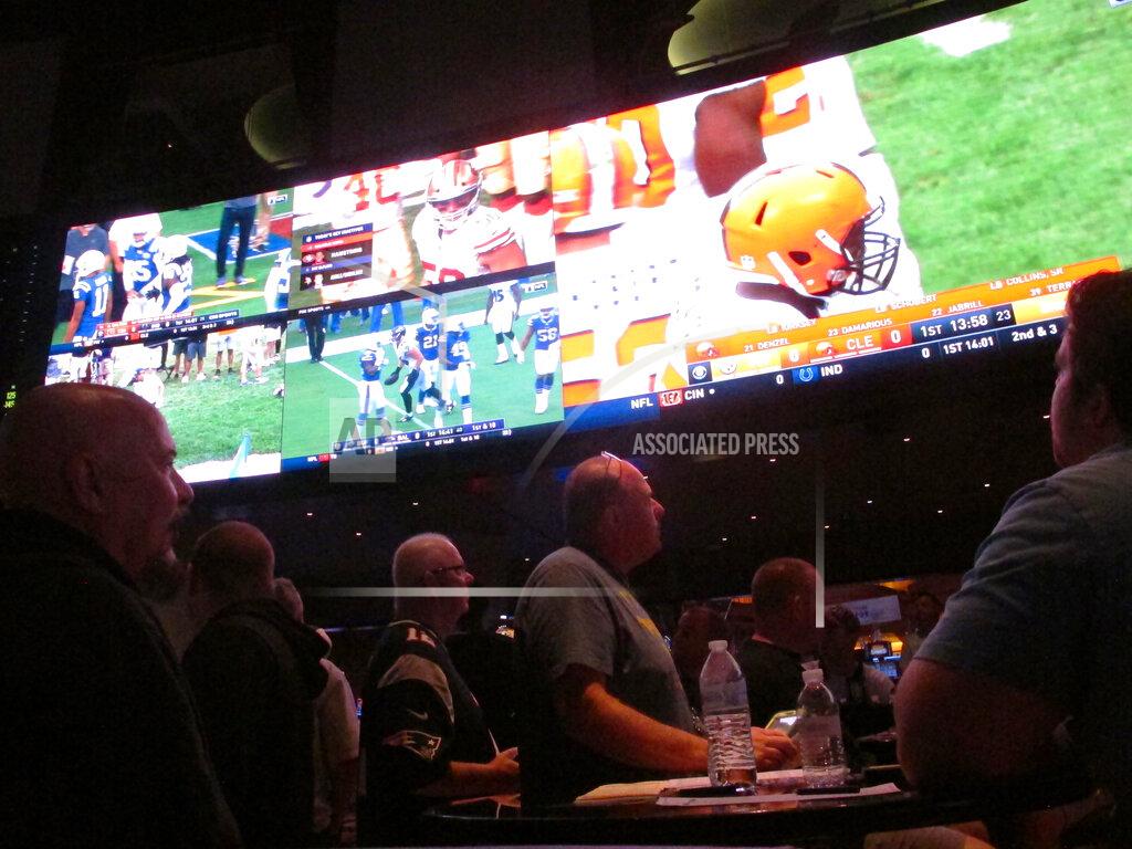 Wayne Parry Customers watch an NFL game in the sports betting lounge at the Ocean Resort Casino in Atlantic City N.J. on Sept. 9, 2018. The coronavirus outbreak has added new wrinkles for bettors this year, but even so, the nation's sportsbooks expect a record year of bets on football in 2020 from an antsy public that has been cooped up for months amid the pandemic. (AP Photo/Wayne Parry)