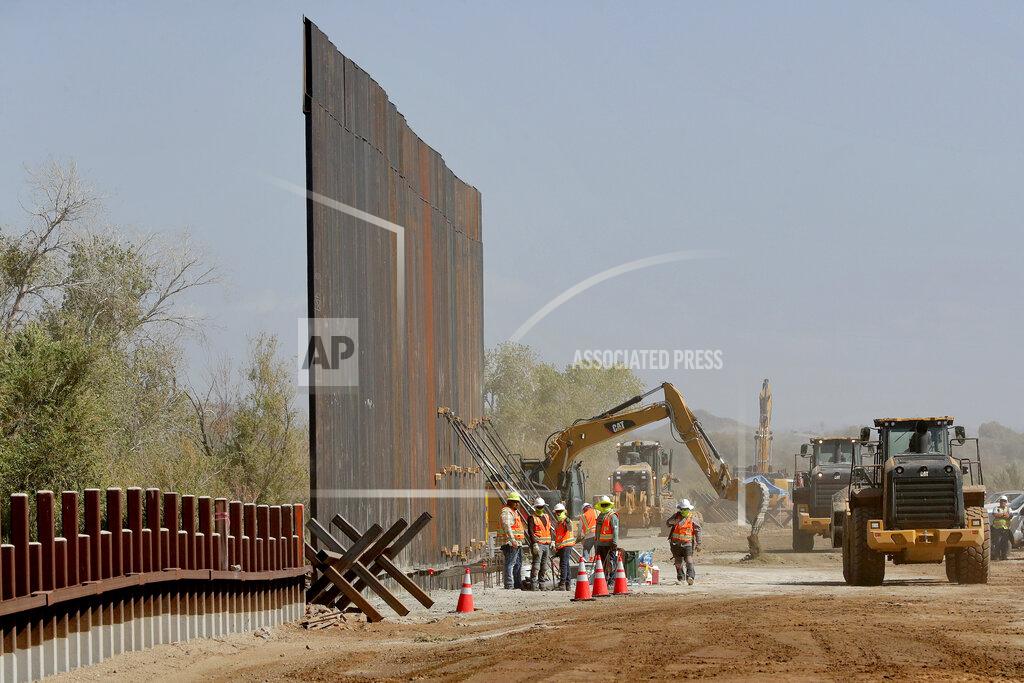Matt York FILE - Contractors erect a section of border wall, replacing smaller fortifications, Tuesday, Sept. 10, 2019, along the Colorado River in Yuma, Ariz. Top Trump administration officials will visit South Texas five days before Election Day to announce they have completed 400 miles of U.S.-Mexico border wall, attempting to show progress on perhaps the president's best-known campaign promise four years ago. But most of the wall went up in areas that already had smaller barriers. (AP Photo/Matt York)