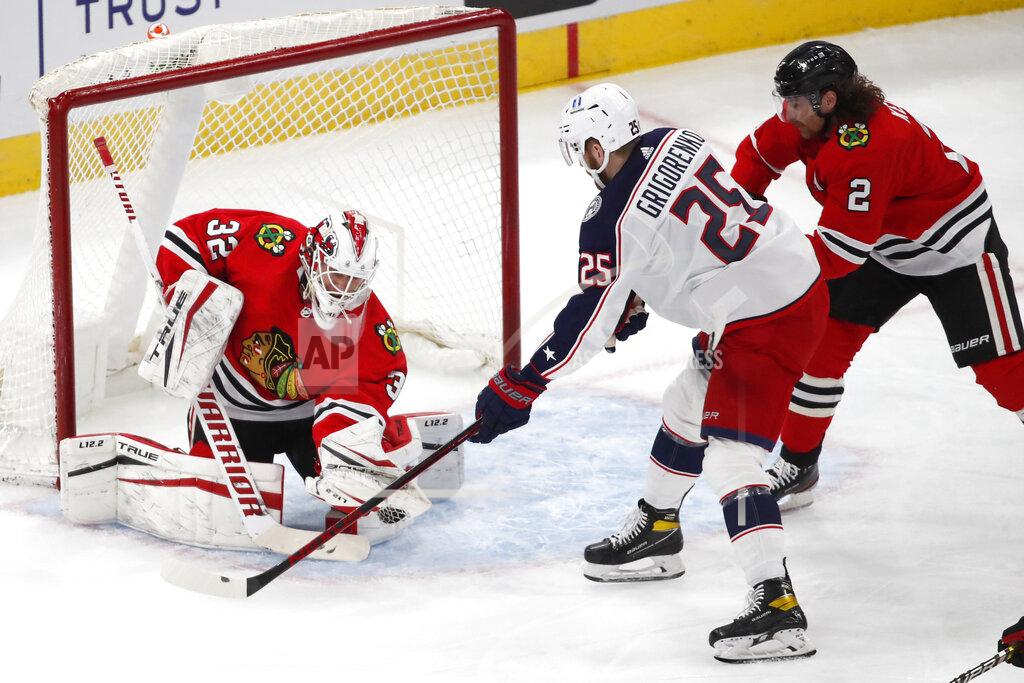 Jeff Haynes Chicago Blackhawks goaltender Kevin Lankinen (32) stops the shot of Columbus Blue Jackets center Mikhail Grigorenko (25) as Blackhawks defenseman Duncan Keith (2) defends during the second period of an NHL hockey game Sunday, Jan. 31, 2021, in Chicago. (AP Photo/Jeff Haynes)
