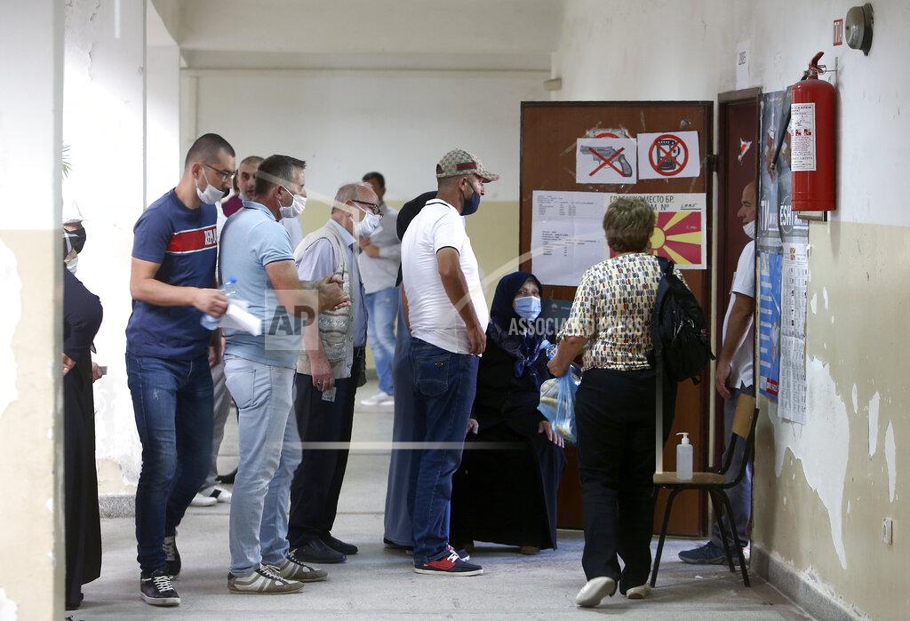 Boris Grdanoski People wearing face masks queue to vote in the parliamentary elections in front of a polling station in Skopje, North Macedonia on Wednesday, July 15, 2020. Voters in North Macedonia headed to the polls on Wednesday in the country's general election despite an alarming spike in coronavirus cases in the tiny Balkan nation. (AP Photo/Boris Grdanoski)