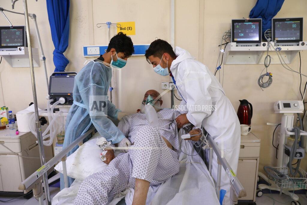 Rahmat Gul Sons help with their father at the Afghan-Japan Communicable Disease Hospital in Kabul, Afghanistan, Sunday, May 30, 2021. Afghanistan is battling a brutal third wave of COVID infections, while health officials plead for vaccines, expressing deep frustration at the inequities of the global vaccine distribution. Positive COVID cases jump from eight percent to 60 per cent in some parts of the country. (AP Photo/Rahmat Gul)