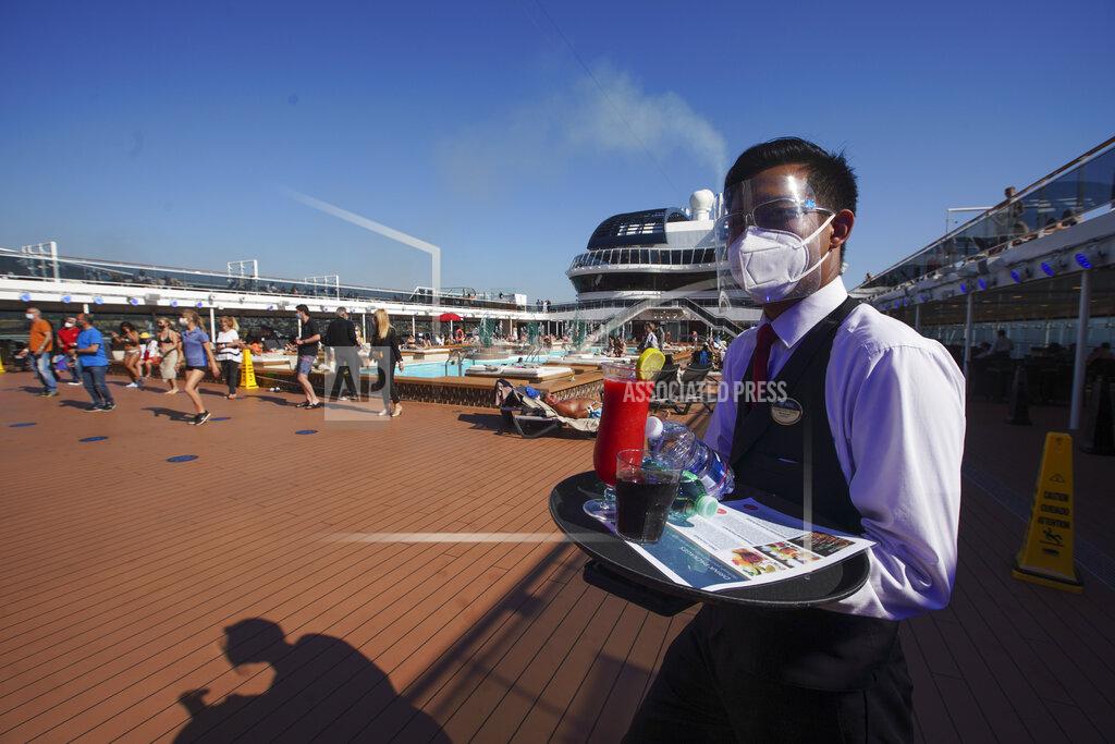 Andrew Medichini A waiter, wearing Covid-19 protection devices holds a tray of drinks on the MSC Grandiosa cruise ship in Civitavecchia, near Rome, Wednesday, March 31, 2021. MSC Grandiosa, the world's only cruise ship to be operating at the moment, left from Genoa on March 30 and stopped in Civitavecchia near Rome to pick up more passengers and then sail toward Naples, Cagliari, and Malta to be back in Genoa on April 6. For most of the winter, the MSC Grandiosa has been a lonely flag-bearer of the global cruise industry stalled by the pandemic, plying the Mediterranean Sea with seven-night cruises along Italy’s western coast, its major islands and a stop in Malta. (AP Photo/Andrew Medichini)