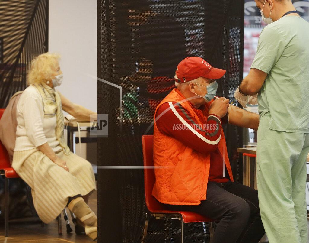 Czarek Sokolowski People getting their COVID-19 jabs at a temporary vaccination center at the National Stadium in Warsaw, Poland, Wednesday, April 7, 2021 as the government is stepping up the tempo of nationwide inoculation. New regulations brought order into the vaccination procedure at the stadium center, after a crowd and long lines formed there on Tuesday. (AP Photo/Czarek Sokolowski)