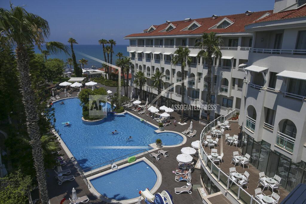 Emrah Gurel Tourists use a swimming pool in a hotel in Antalya, southern Turkey, Saturday, June 19, 2021. Hotels in Turkey's Antalya region, a destination beloved by holidaymakers, are preparing to finally resume operations as they expect the return of international tourists after months of setbacks caused by the pandemic that halted travel. (AP Photo/Emrah Gurel)