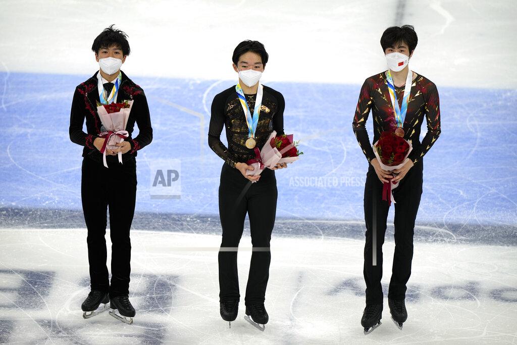 Mark Schiefelbein From left, men's singles silver medalist Shun Sato of Japan, gold medalist Yuma Kagiyama of Japan, and bronze medalist Jin Boyang of China pose on the ice during their medal ceremony at the Asian Open Figure Skating Trophy, a test event for the 2022 Winter Olympics, at the Capital Indoor Stadium in Beijing, Friday, Oct. 15, 2021. (AP Photo/Mark Schiefelbein)