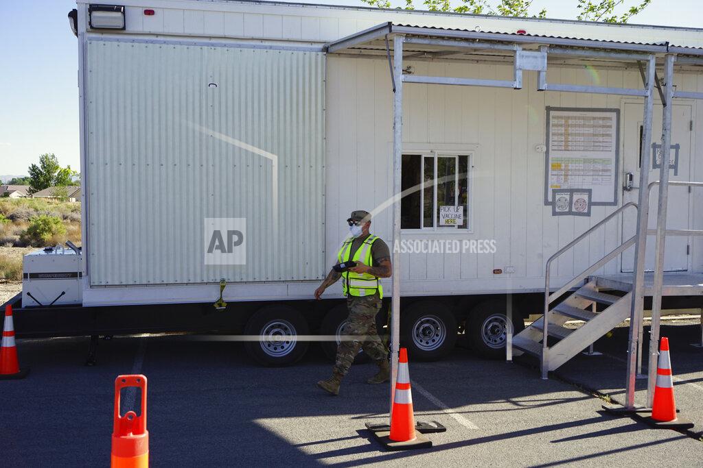 Sam Metz A Nevada National Guardsman leaves a portable trailer that the Federal Emergency Management Agency designed as mobile vaccination unit on May 18, 2021, in Fallon, Nev. It's one of several methods health officials are employing here and across the country to bring vaccines directly to people to counter waning demand. In tiny towns, ballparks, strip clubs, and marijuana dispensaries, officials are setting up shop and offering incentives to entice people who so far have not gotten shots. (AP Photo/Sam Metz)