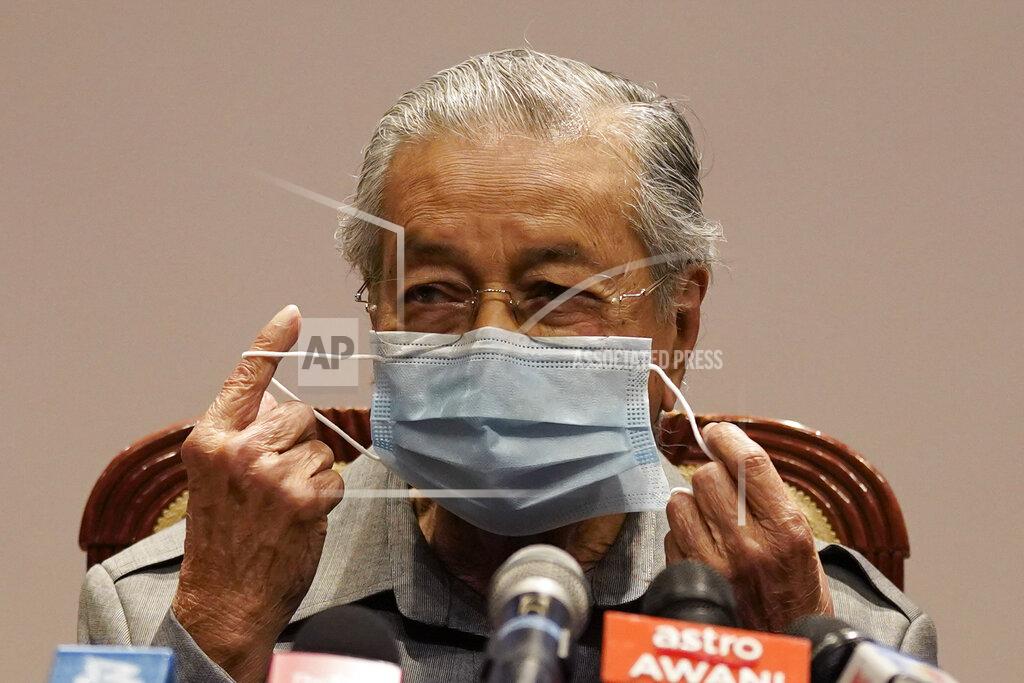 Vincent Thian Malaysia former Prime Minister Mahathir Mohamad removes his face mask before a press conference at his office of Perdana Foundation in Putrajaya, Malaysia, Monday, May 18, 2020. Mahathir slammed the government for using the pandemic as an excuse to block parliament from sitting. The king in his speech urged lawmakers not to stir up another political crisis but to focus on the people's welfare amid the virus outbreak. (AP Photo/Vincent Thian)