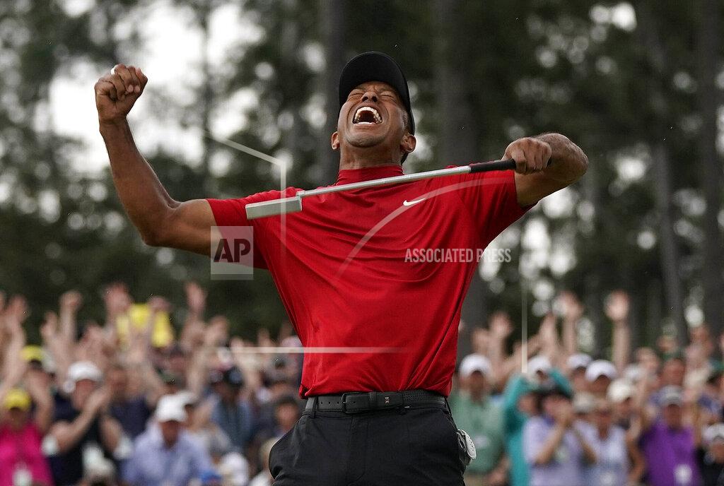 David J. Phillip File-This April 14, 2019, file photo shows Tiger Woods reacting as he wins the Masters golf tournament in Augusta, Ga. Woods stands tall in the Georgia pines. Hugs and chants and exultation, Masters crown, a restoration. (AP Photo/David J. Phillip,File)